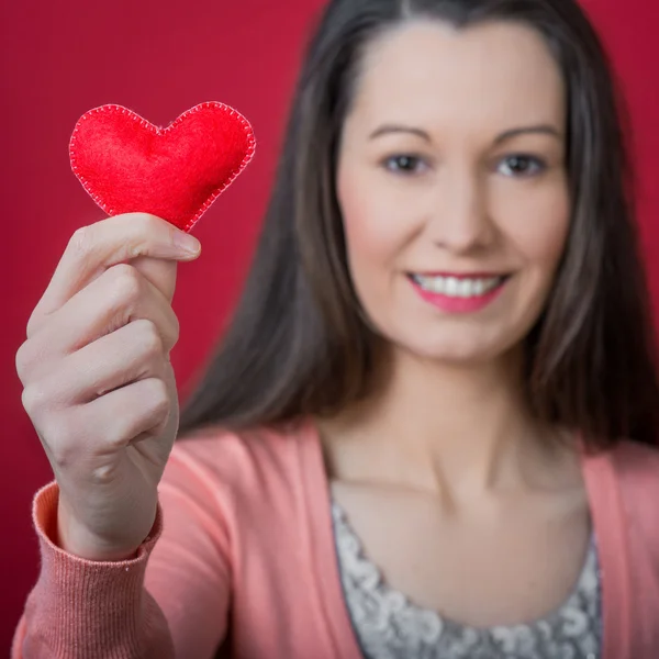 Young woman holds a heart — Stock Photo, Image