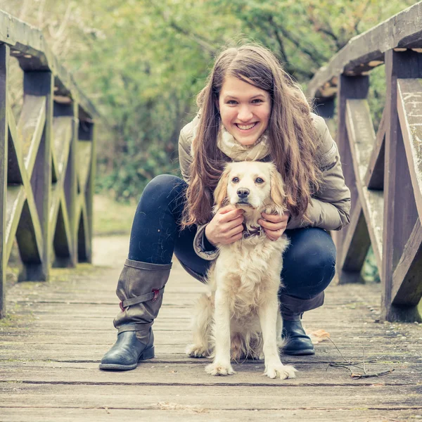 En tjej som är avkopplande utanför med sin hund. — Stockfoto