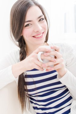 çekici genç bir kadın kahve içmek kanepe