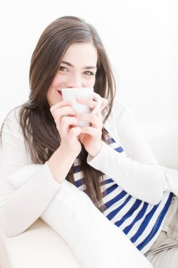 çekici genç bir kadın kahve içmek kanepe