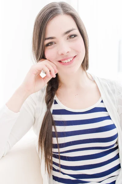 Jovem mulher relaxante e sorrindo em casa — Fotografia de Stock