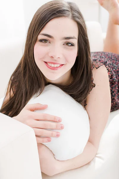 Jovem mulher relaxante e sorrindo em casa — Fotografia de Stock