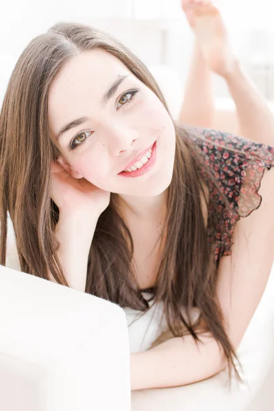 Fiatal nő, pihentető és mosolyogva otthon — Stock Fotó