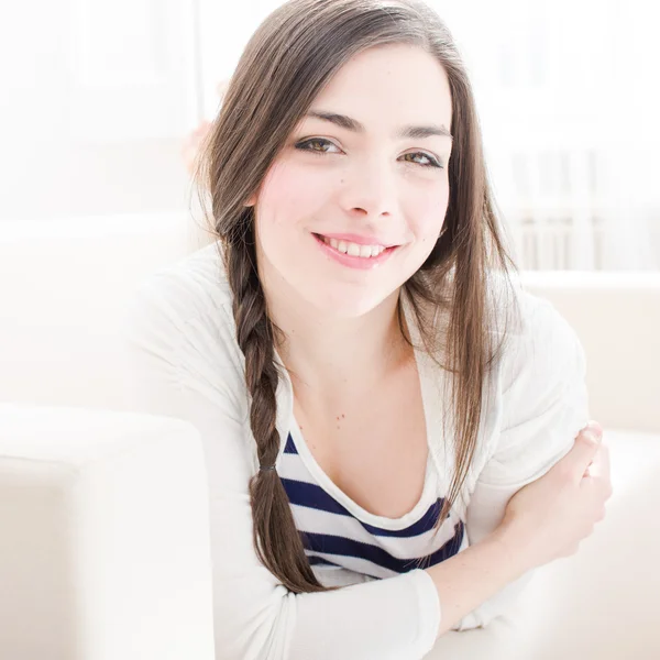 Mujer joven relajándose y sonriendo en casa —  Fotos de Stock