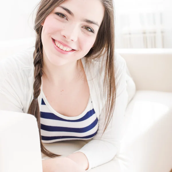 Mujer joven relajándose y sonriendo en casa Fotos de stock libres de derechos