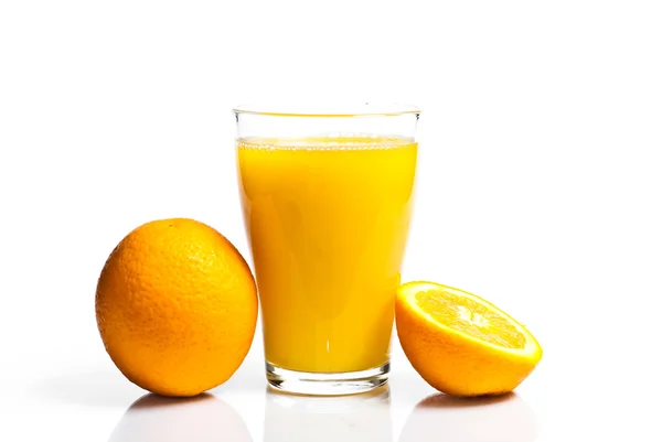 Ein Glas Orangensaft und Orangen — Stockfoto