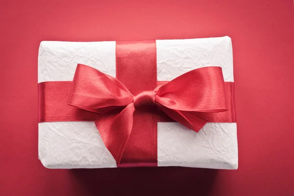 White gift on red background — Stock Photo, Image