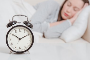 çalar saat tablo ve arka planda uyuyan kadın