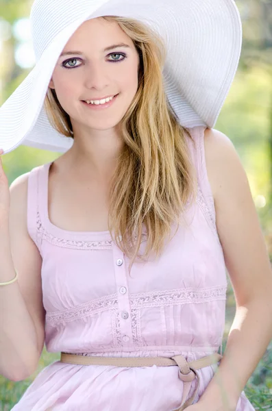 Mooie jonge vrouw die lacht in zon hoed buitenshuis — Stockfoto