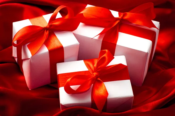 Geschenkboxen mit einer Schleife aus rotem Satinband gebunden — Stockfoto
