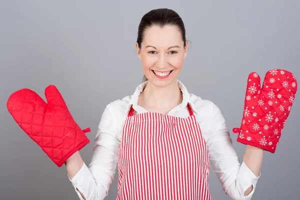 Woman with oven mittens and red apron — Stock Photo, Image