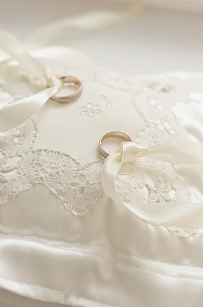 Golden wedding rings on small white cushion — Stock Photo, Image