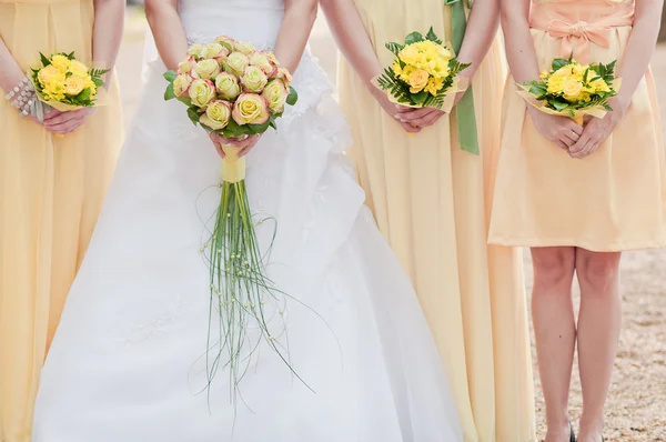 Tre mazzi di fiori nuziali tenuti da una sposa e le sue damigelle — Foto Stock