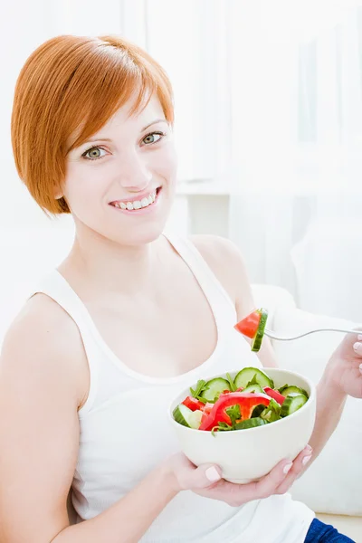 Gros plan de la jeune femme heureuse qui mange de la salade — Photo