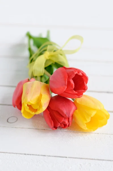 Yellow and red tulip flowers on white wooden background — Stock Photo, Image