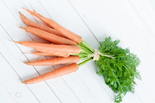 Bunch orange carrots with green leaves isolated over white — Stock Photo, Image