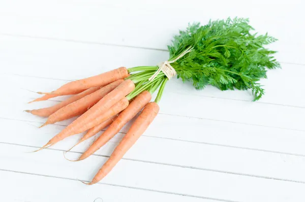 Bunch orange carrots with green leaves isolated over white — Stock Photo, Image