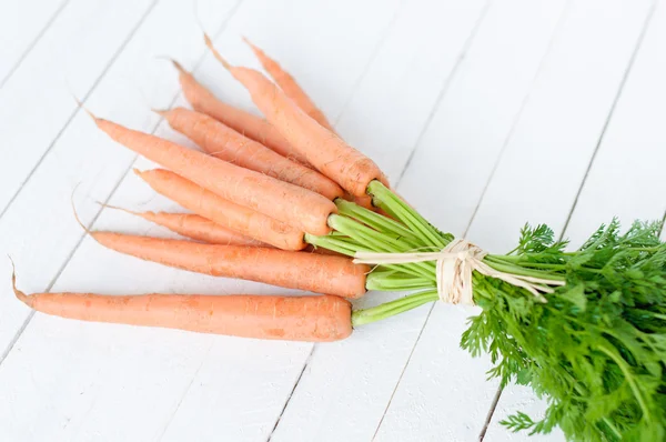 Bunch orange carrots with green leaves isolated over white — Stock Photo, Image