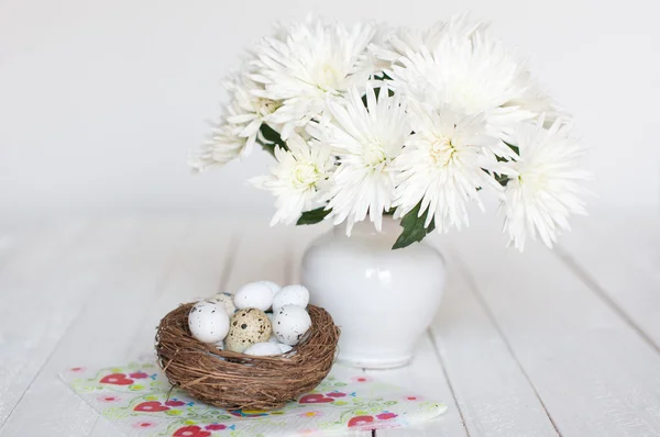 Diferentes tipos de huevos en un nido sobre un fondo de madera blanca —  Fotos de Stock
