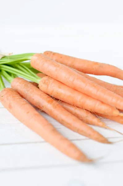Ramo de zanahorias de color naranja con hojas verdes aisladas sobre blanco —  Fotos de Stock