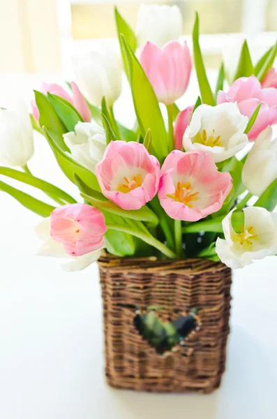 Roze en witte tulpen in een rieten mand — Stockfoto