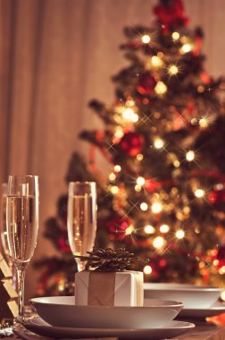 Şampanya kadehli süslü bir Noel yemeği masası.