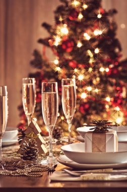 Şampanya kadehli süslü bir Noel yemeği masası.