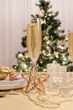 Şampanya kadehli süslü bir Noel yemeği masası.