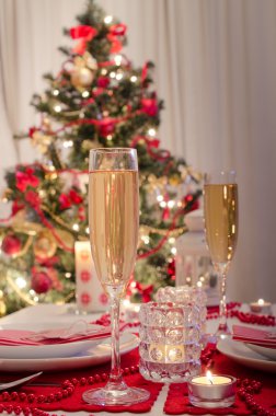 Şampanya kadehli süslü bir Noel yemeği masası.
