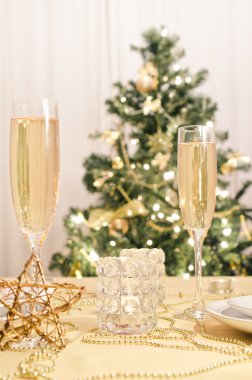 Şampanya kadehli süslü bir Noel yemeği masası.