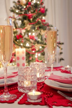 Şampanya kadehli süslü bir Noel yemeği masası.