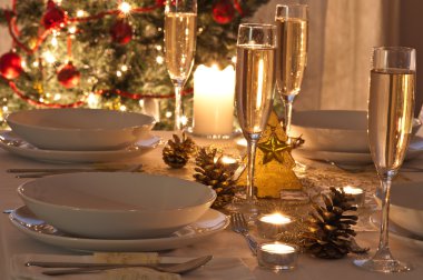 Şampanya kadehli süslü bir Noel yemeği masası.