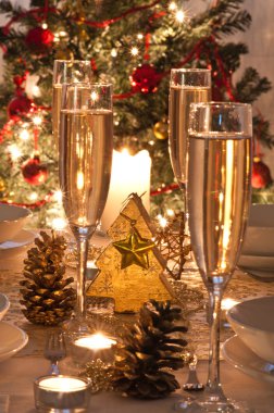 Şampanya kadehli süslü bir Noel yemeği masası.
