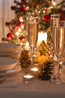 Şampanya kadehli süslü bir Noel yemeği masası.