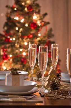 Şampanya kadehli süslü bir Noel yemeği masası.