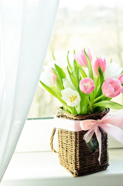 Pink and white tulips in a wicker basket — Stock Photo, Image