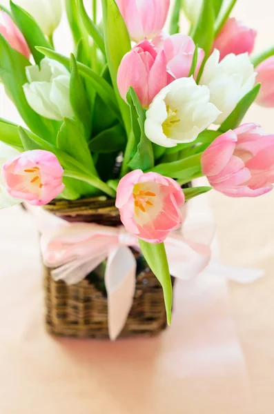 Roze en witte tulpen in een rieten mand — Stockfoto