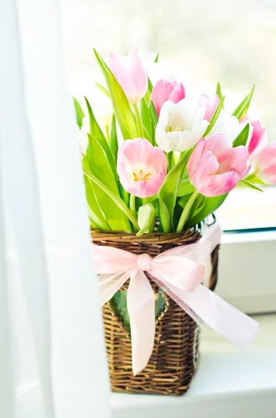 Pink and white tulips in a wicker basket — Stock Photo, Image