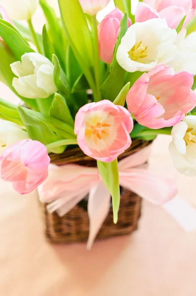 Rosa och vita tulpaner i en flätad korg — Stockfoto