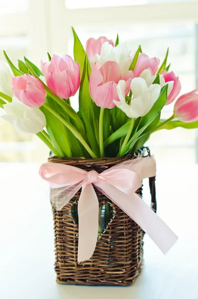 Roze en witte tulpen in een rieten mand — Stockfoto