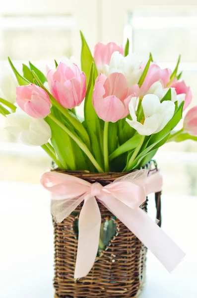 Pink and white tulips in a wicker basket — Stock Photo, Image