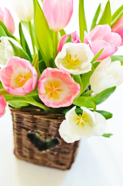 Roze en witte tulpen in een rieten mand — Stockfoto