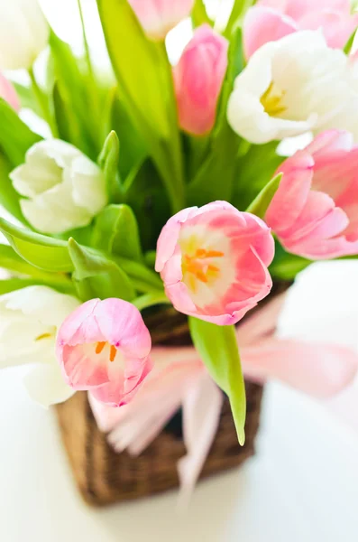 Рожеві та білі тюльпани в плетеному кошику — стокове фото