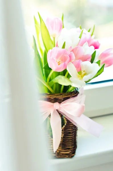 Pink and white tulips in a wicker basket — Stock Photo, Image