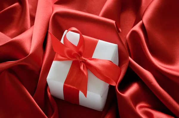 Valentines gift boxes tied with a red satin ribbon bow on red satin background — Stock Photo, Image