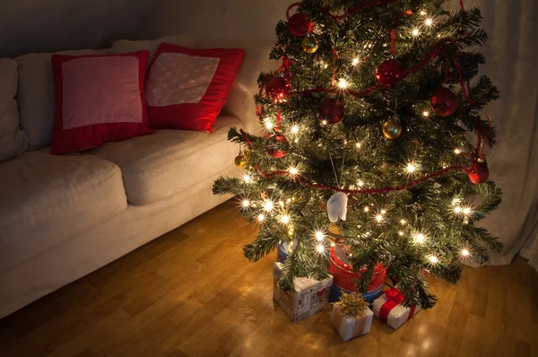 Uma sala de estar iluminada pelo brilho da árvore de Natal . — Fotografia de Stock