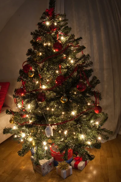 Uma sala de estar iluminada pelo brilho da árvore de Natal . — Fotografia de Stock