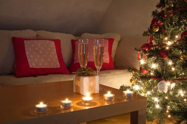 Een woonkamer verlicht door de gloed van de kerstboom. — Stockfoto