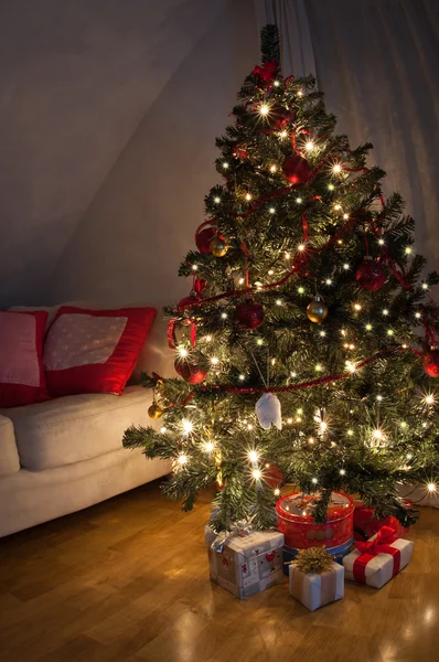 Uma sala de estar iluminada pelo brilho da árvore de Natal . — Fotografia de Stock