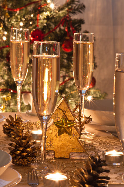 A decorated christmas dining table with champagne glasses